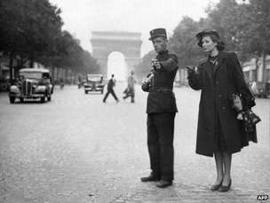 A policeman directs traffic on the Champs Elysees